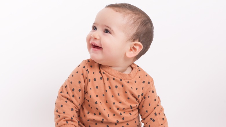 Baby smiling in orange shirt