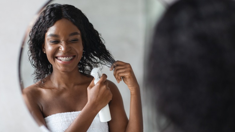 Woman using heat protectant spray