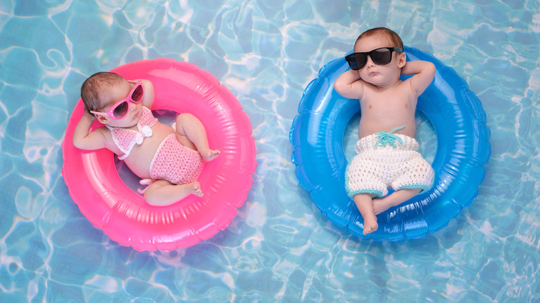 Brother and sister babies hanging at the pool