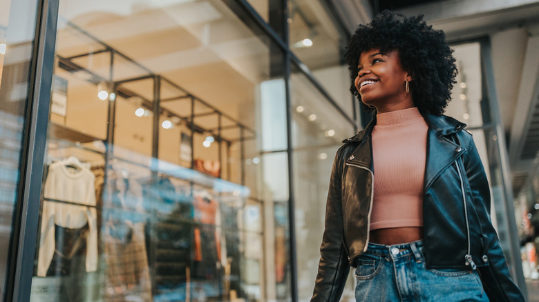 smiling woman walking by shop