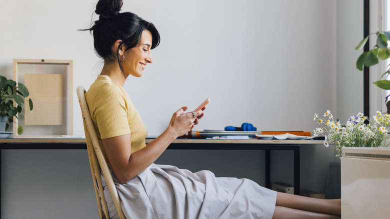 woman smiling looking at phone