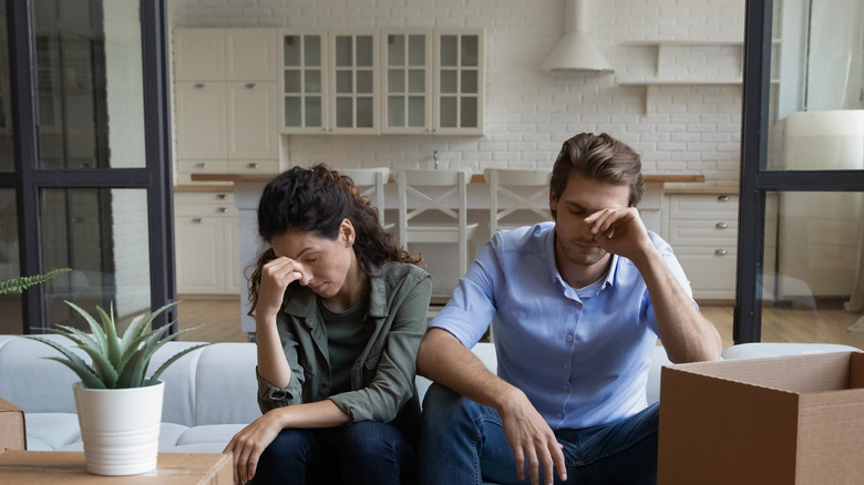 Couple sitting in between cardboard boxes