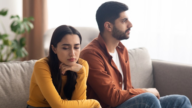 Unhappy couple sitting on the couch