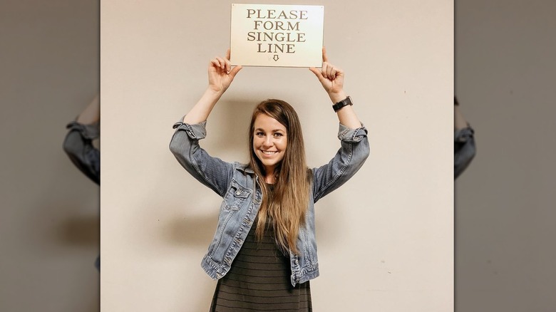 Jana Duggar with sign Please Form Single Line