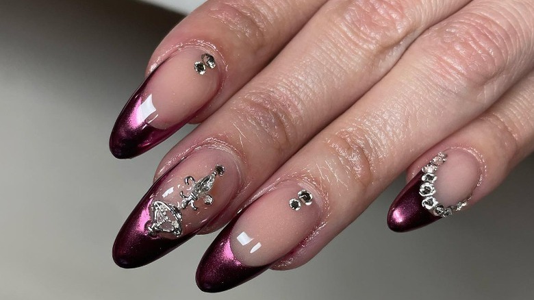 Dark pink chrome tip with jewelry added to nails