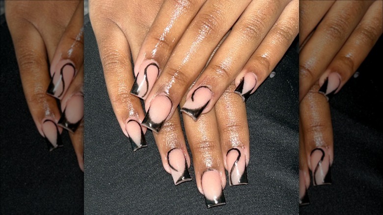 Black French manicure adorned with swirls