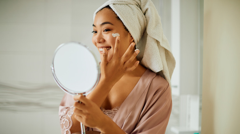 smiling woman applying face cream