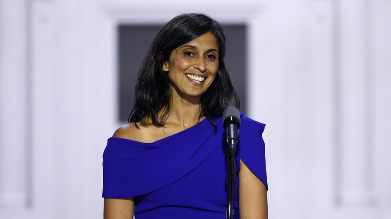 Usha Vance smiling and standing behind a microphone