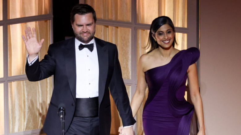 JD Vance waves as Usha Vance holds his hand and smiles