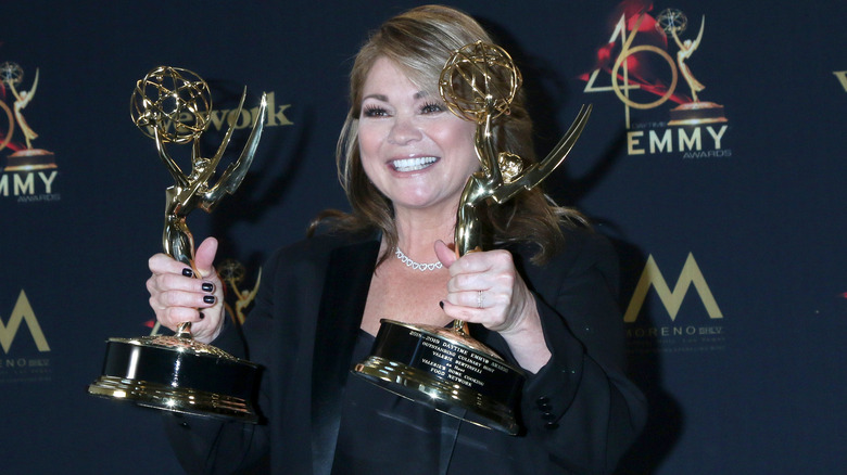 Valerie Bertinelli smiling as she holds up two Emmys