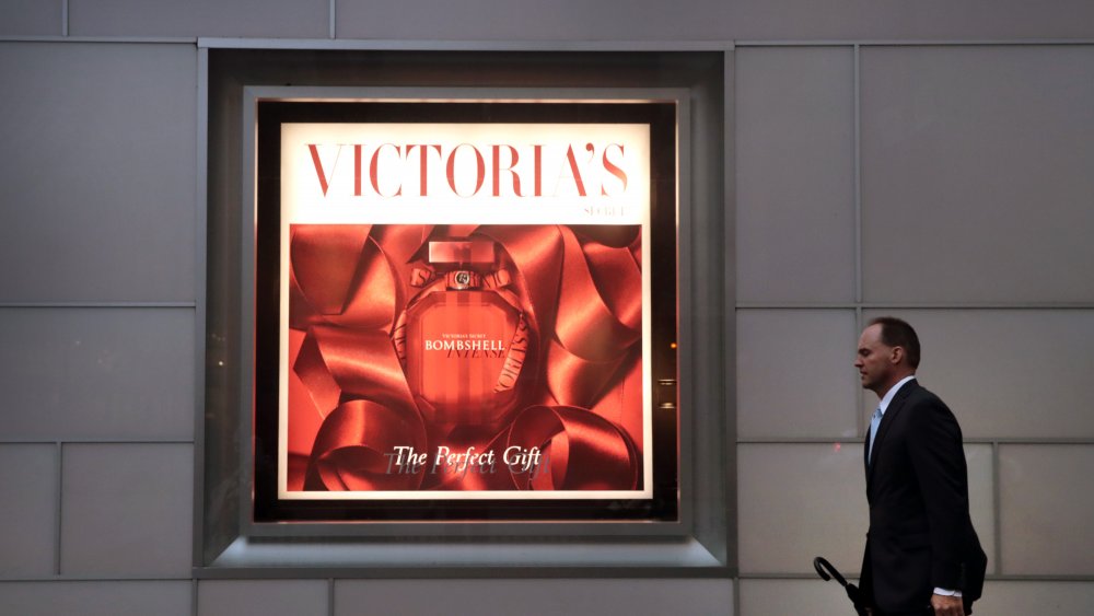 Man walking past a Victoria's Secret poster