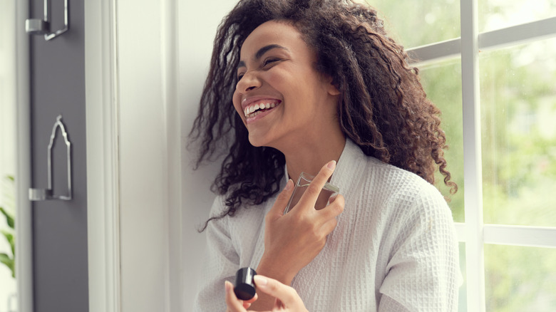 Woman putting on perfume