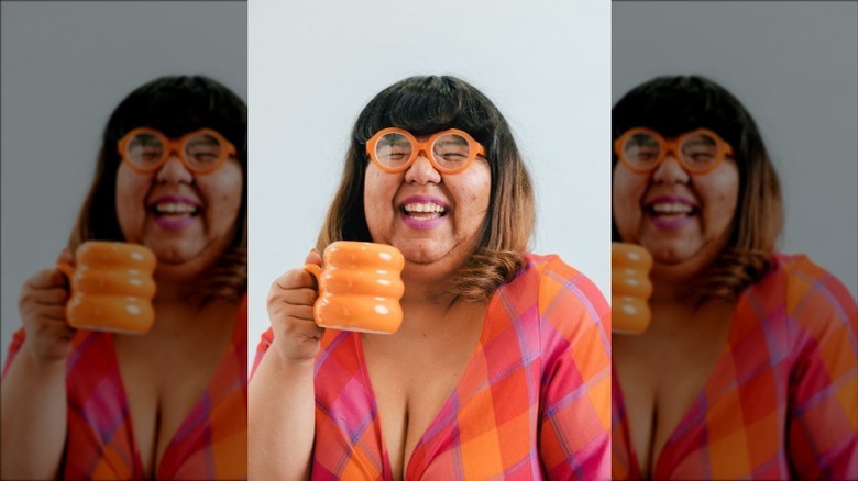 Virgie Tovar laughing and holding orange mug