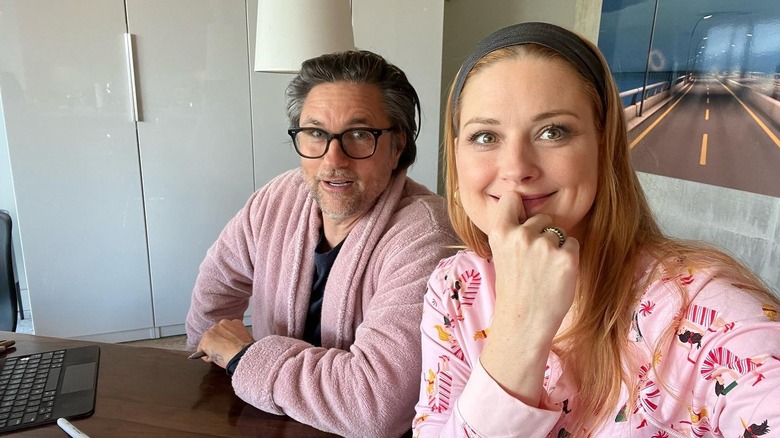 Martin Henderson and Alexandra Breckenridge in pajamas while signing autographs