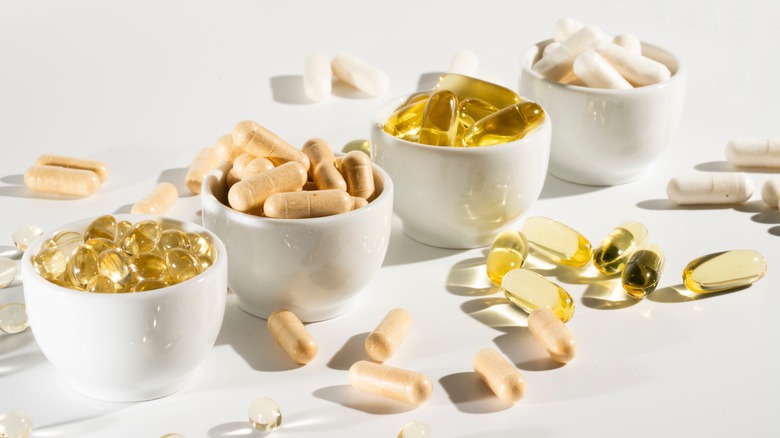 tiny overfilled bowls containing vitamin capsules