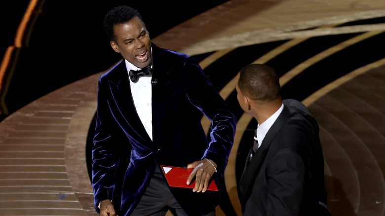 Chris Rock reacts to being slapped by Will Smith onstage at the Oscars