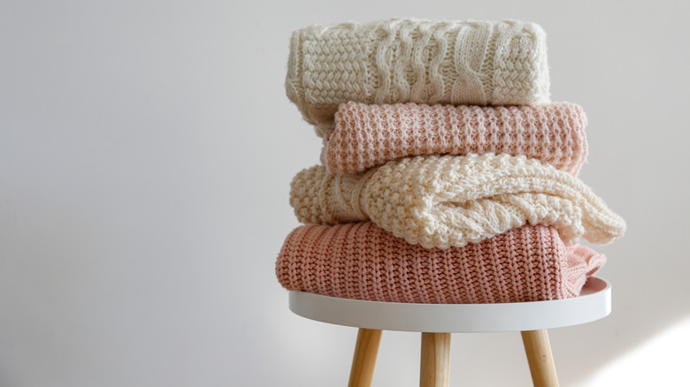 Stack of sweaters on top of table