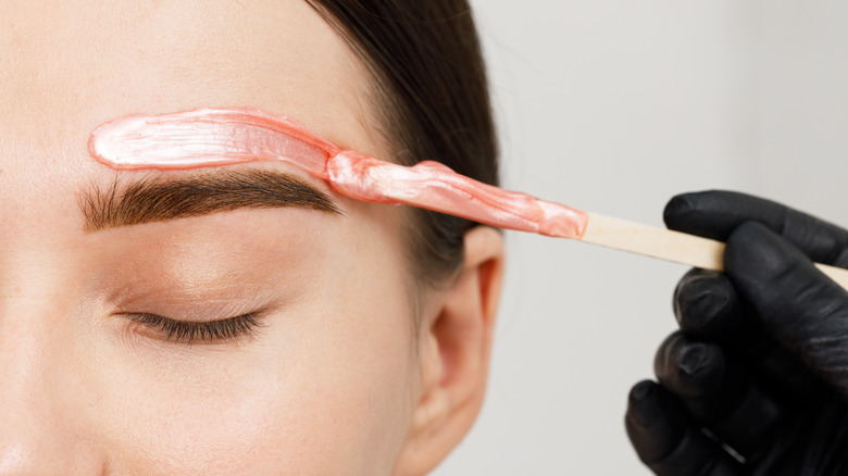 Woman waxing eyebrow