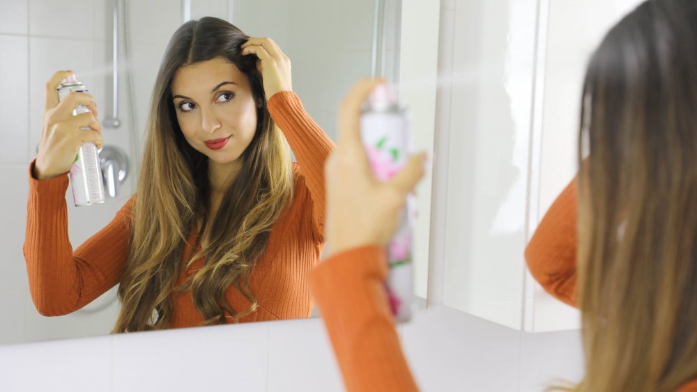 Woman applying dry shampoo