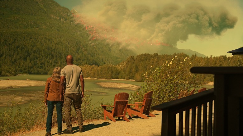 Annette O'Toole (Hope) and Colin Lawrence (Preacher) look out on wildfire in production still of "Virgin River"