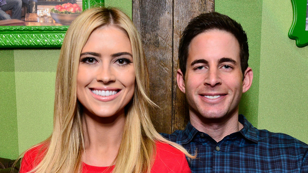 Christina Haack and Tarek El Moussa in front of a green wall