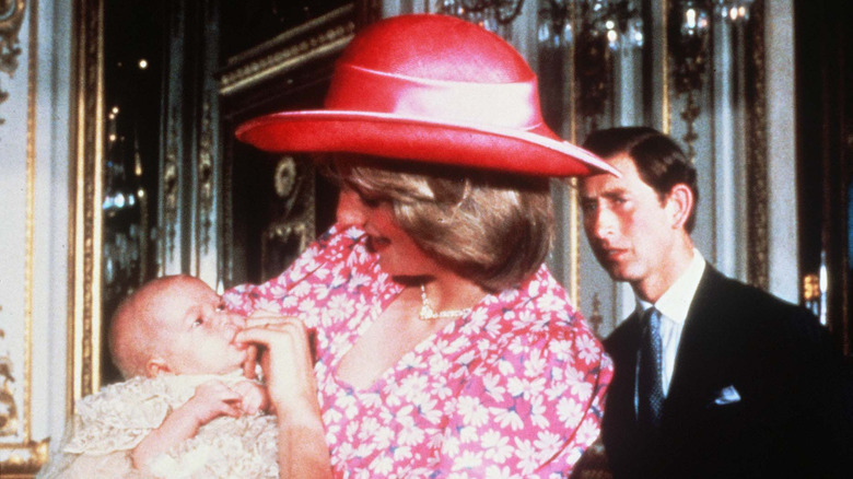 Princess Diana holding her baby, Prince Charles behind her