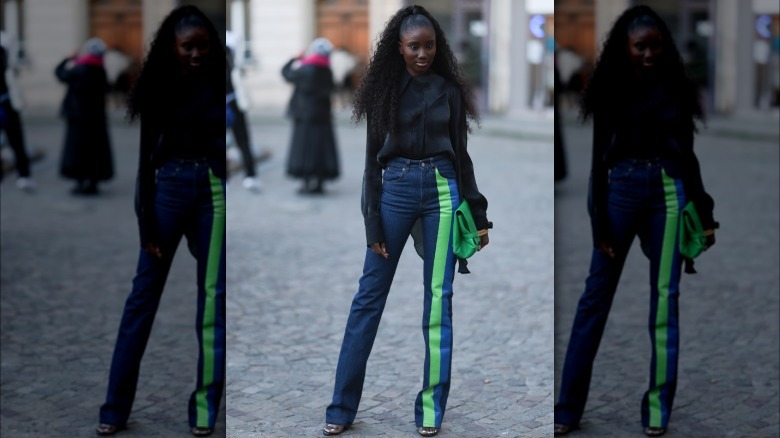 Woman wears black sweater and navy blue jeans