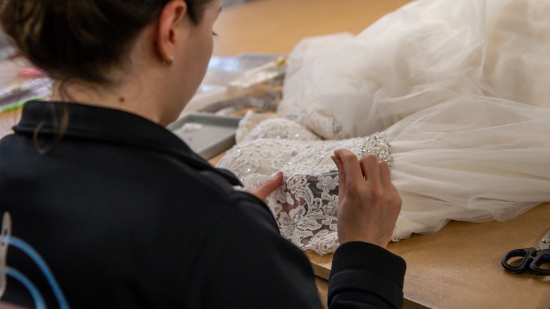 A wedding dress tailor tends to wedding dress changes