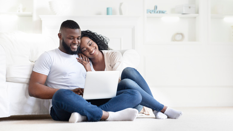 Couple smiles on laptop