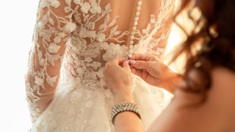 Woman doing up a wedding dress