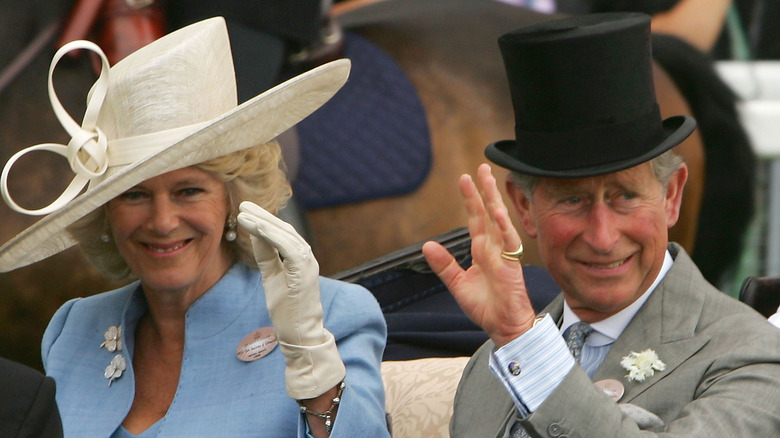 Camilla and Prince Charles wearing hats, waving