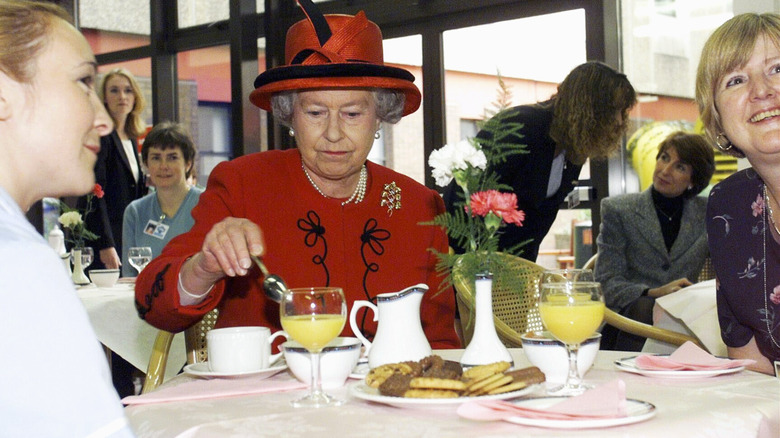 Queen Elizabeth stirring tea