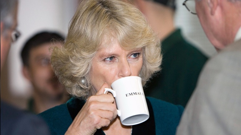 Queen Camilla sipping a mug of tea at the Emmaus community centre