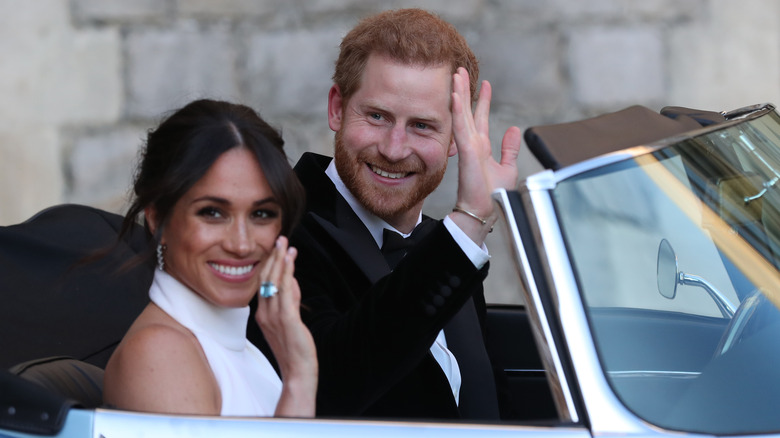 Prince Harry and Meghan Markle waving as they drive away