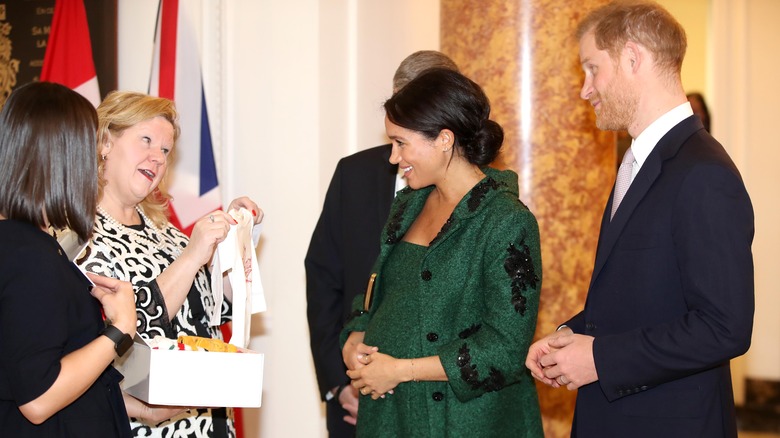 Meghan and Harry accepting present for baby