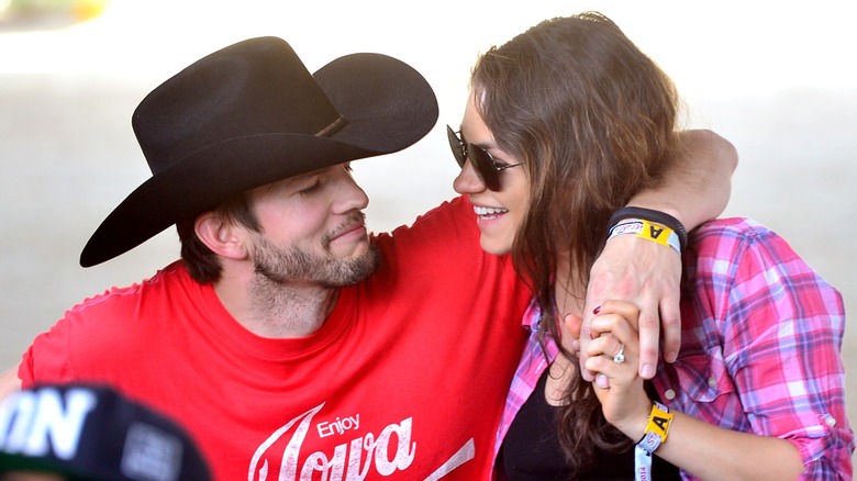 Ashton Kutcher with arm around Mila Kunis