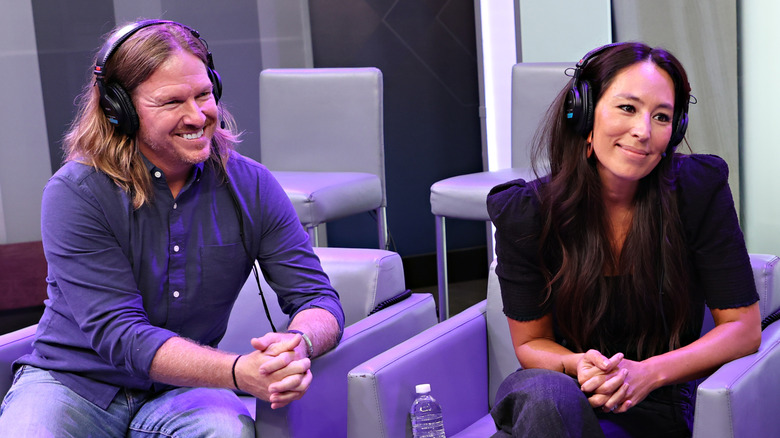 Chip and Joanna Gaines smiling in matching chairs with headphones on