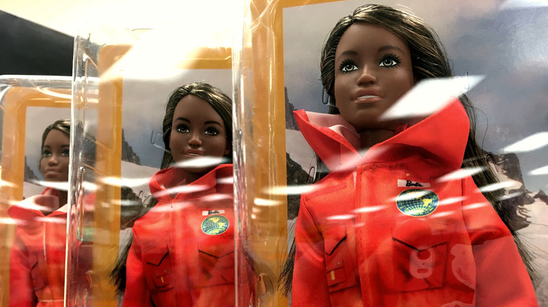 Astronaut Barbies wearing orange jumpsuits 