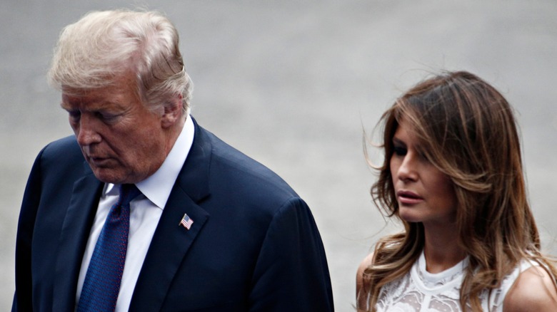 Donald Trump and Melania Trump walking with their heads down