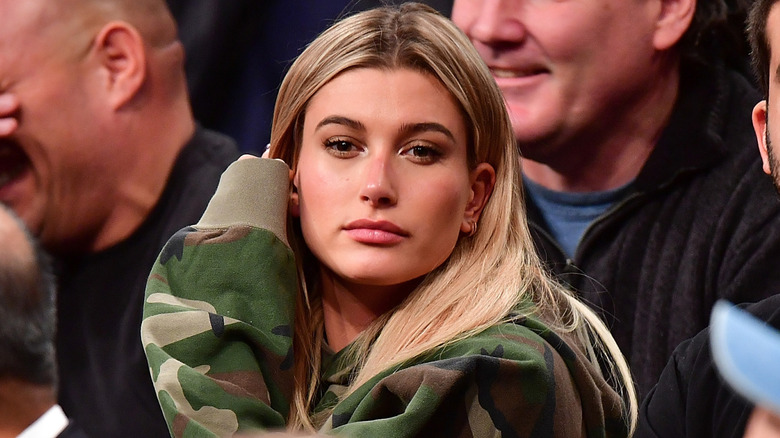 Hailey Bieber sitting at a basketball game