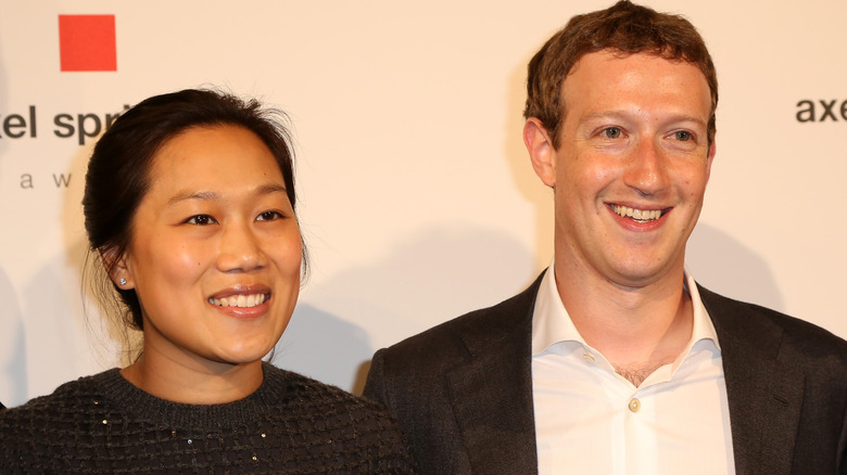 Mark Zuckerberg and Priscilla Chan at a press event smiling