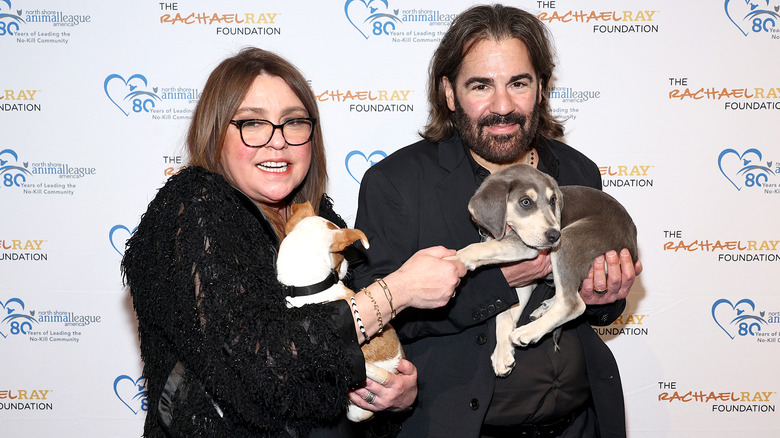 Rachael Ray and John Cusimano posing with puppies at a 2024 celebration of rescue animals