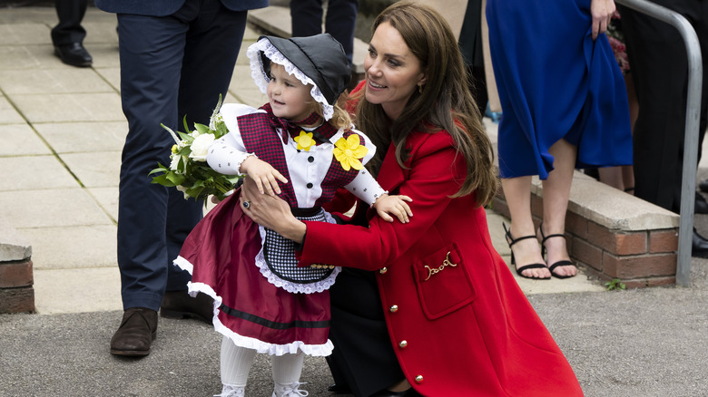 Kate Middleton hugging a girl wearing the Welsh national costume