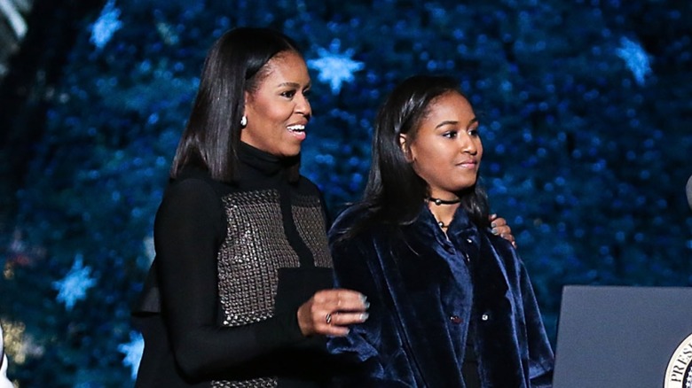 Michelle Obama holding Sasha Obama's arm