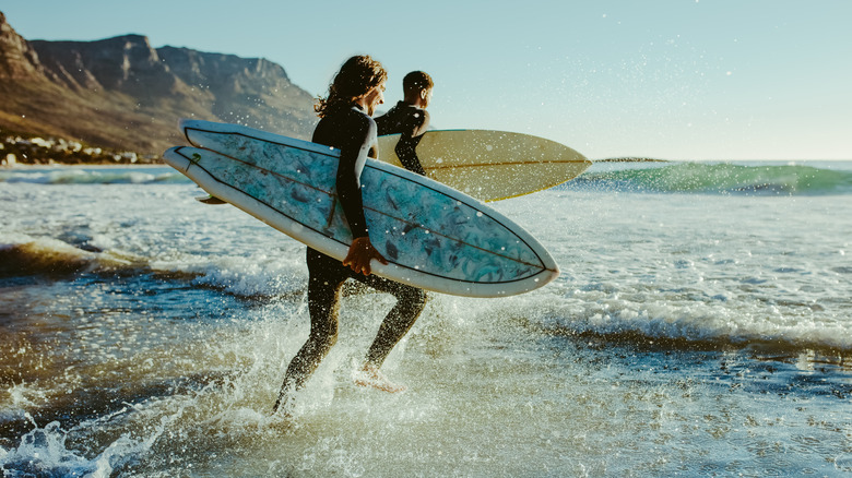 Carrying boards into the surf