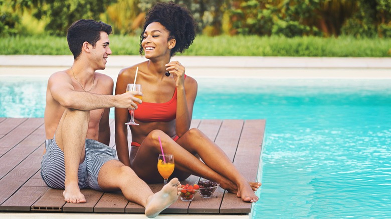 couple flirting beside pool 