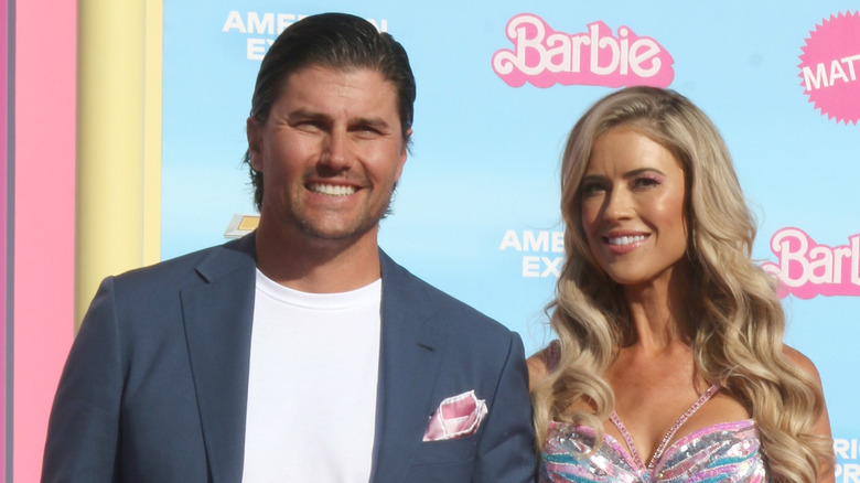 Joshua Hall in a blue suit and white shirt and Christina Haack in a sparkly dress at an event