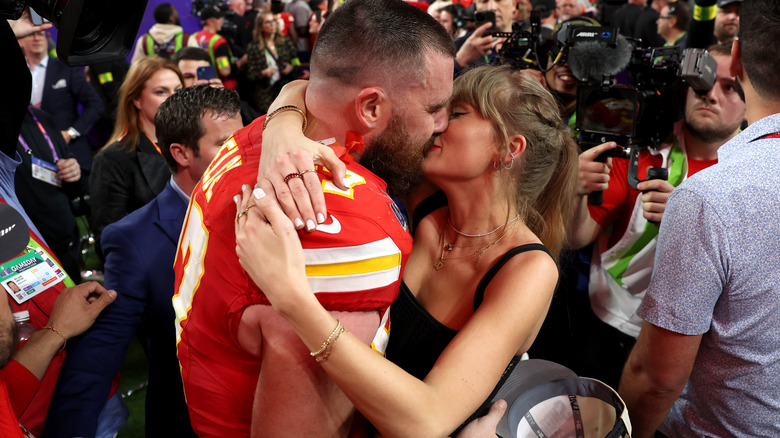 Taylor Swift and Travis Kelce kissing on the field after the Kansas City Chiefs win the Super Bowl