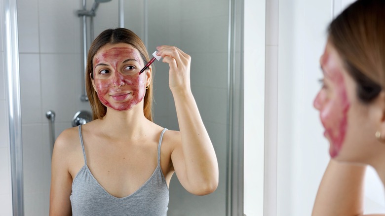 Woman applying BHA solution to face 