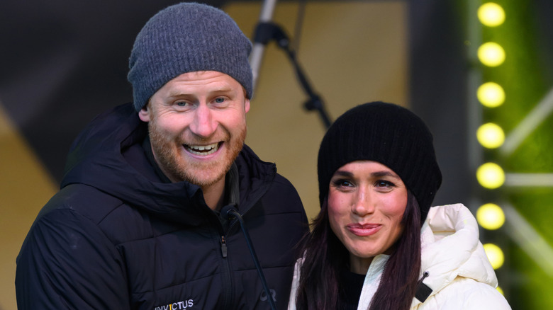 Prince Harry and Meghan Markle smiling in winter attire